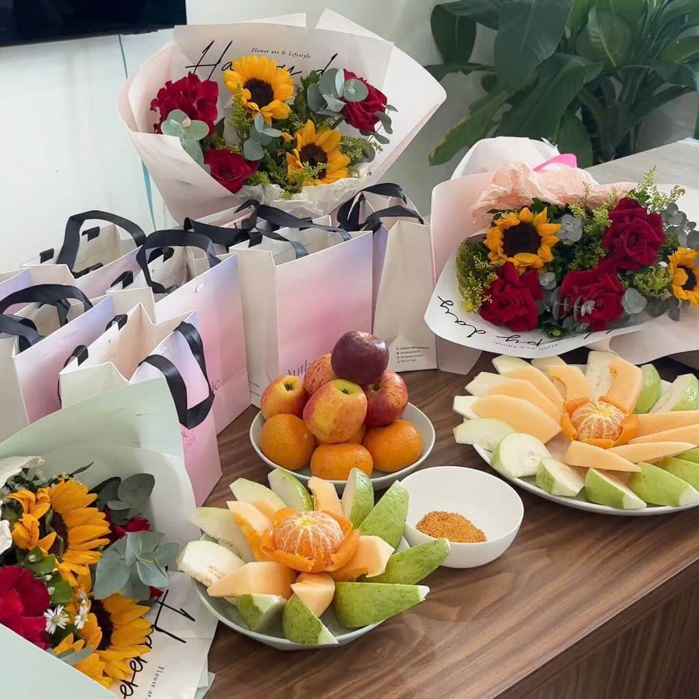 Fruit platters beside bouquets and gift bags at the ISOLUTION LOGISTICS Women's Day gathering